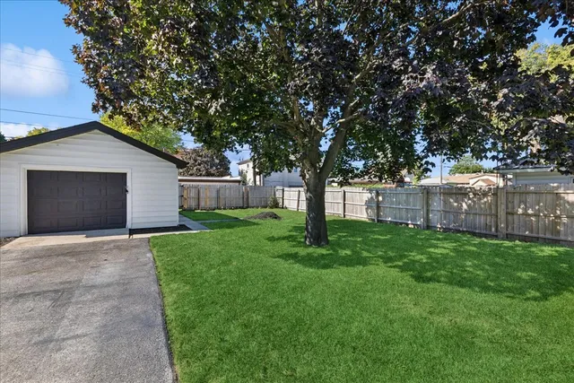 a front view of a house with a yard and a tree