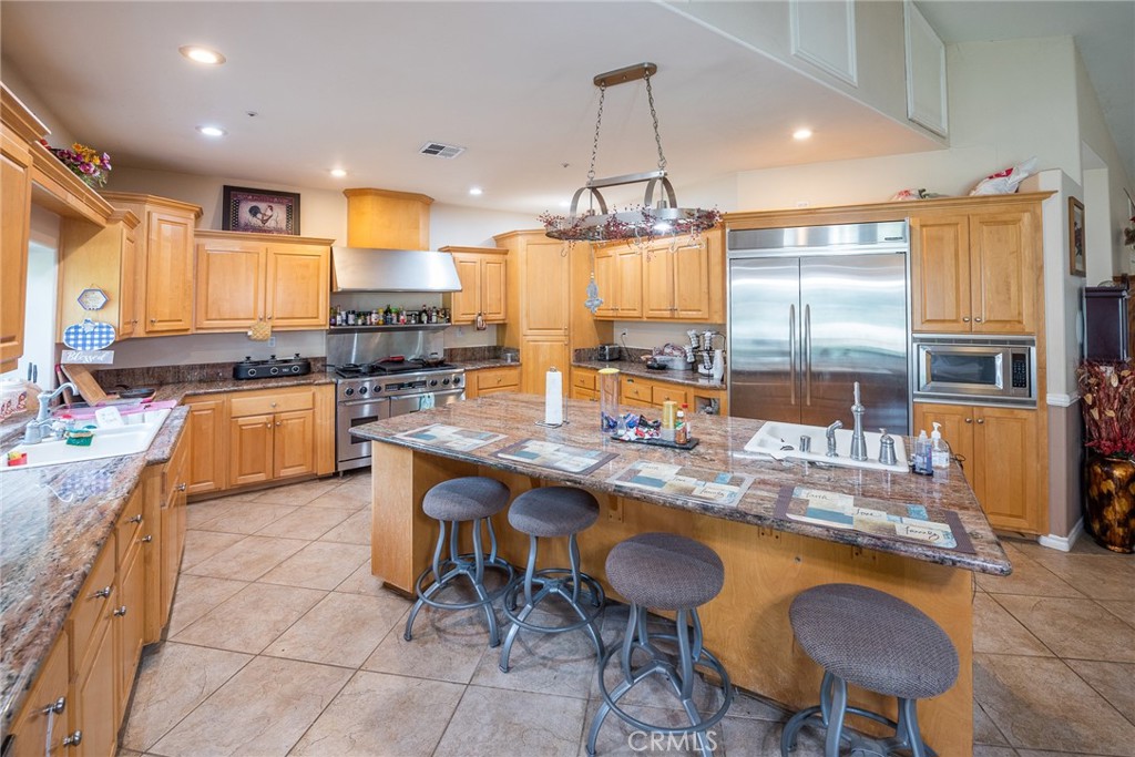 1413 Irving Street Riverside, CA 92504 - Photo 9 of 29 a kitchen with stainless steel appliances granite countertop table chairs sink and cabinets