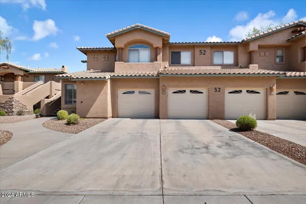 a view of a house with potted plants and a large tree