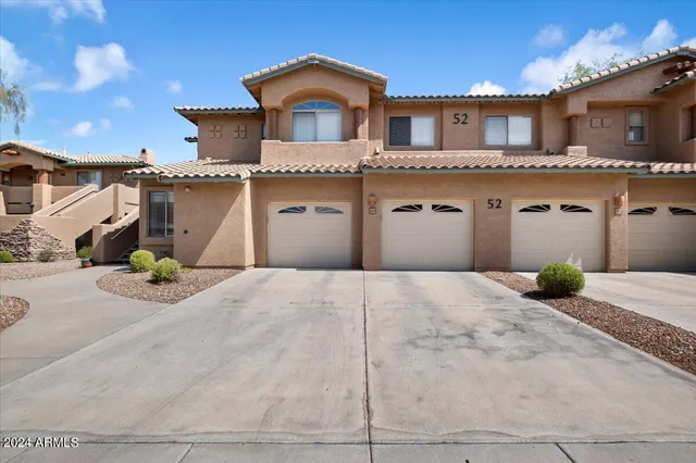 a view of a house with potted plants and a large tree