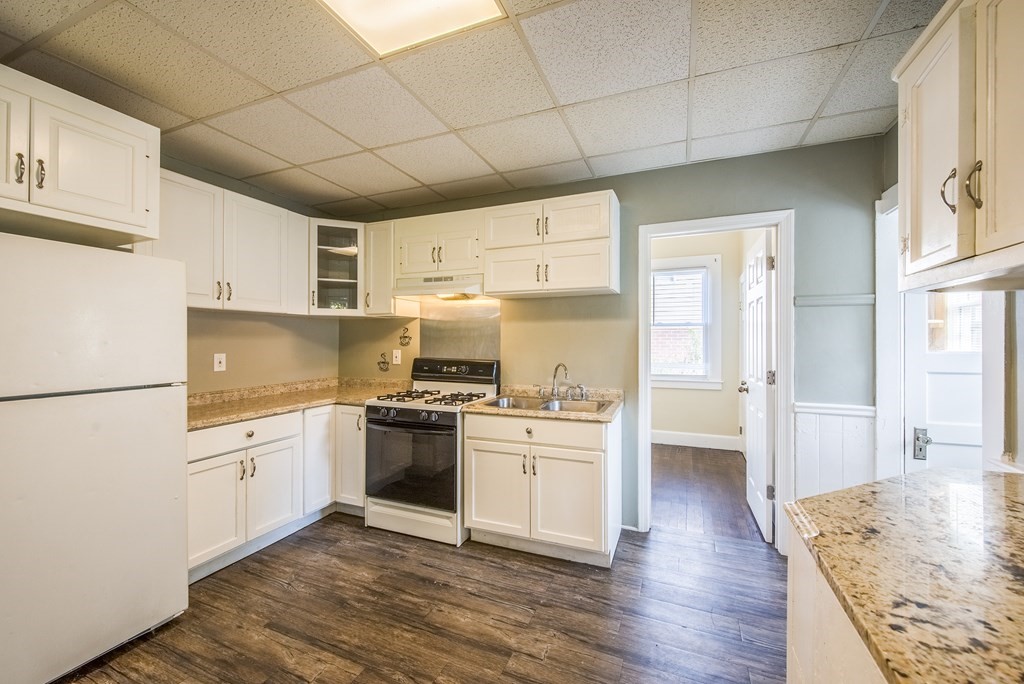 129 Florence Street Springfield, MA 01105 - Photo 13 of 16 a kitchen with granite countertop white cabinets and white appliances