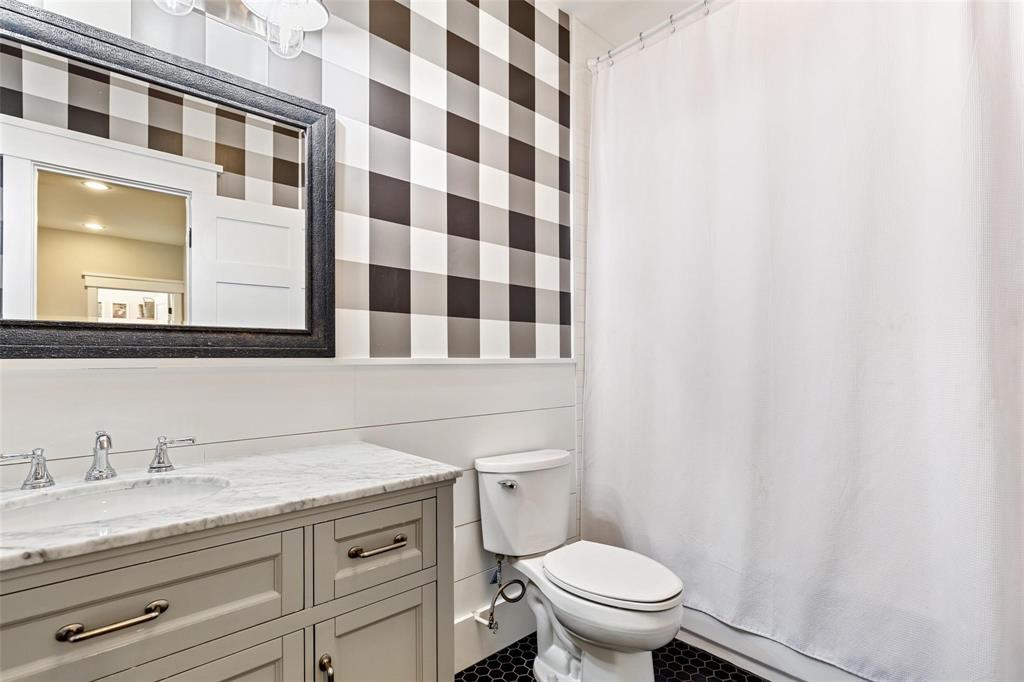 1109 East Oakdale Road Irving, TX 75060 - Photo 26 of 33 a bathroom with a granite countertop toilet a sink and a mirror