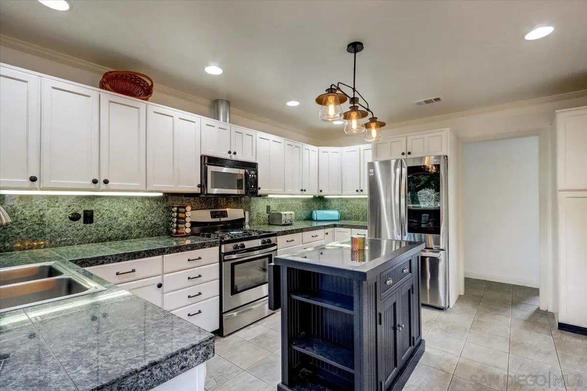 861 Shade Tree Lane Fallbrook, CA 92028 - Photo 13 of 49 a kitchen with granite countertop a sink appliances and cabinets