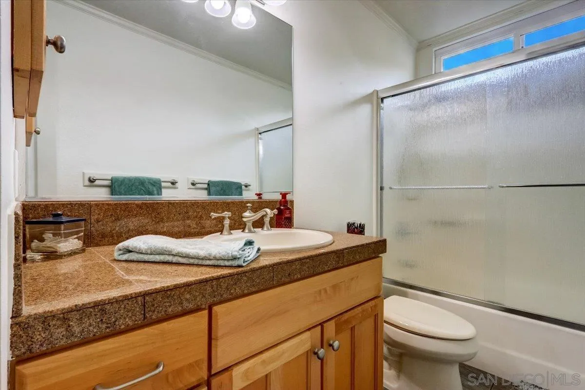 861 Shade Tree Lane Fallbrook, CA 92028 - Photo 16 of 49 a bathroom with a granite countertop sink mirror vanity and toilet