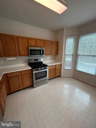 an empty room with windows and fireplace