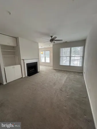 an empty room with fireplace and windows