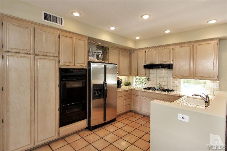3853 Timberridge Road Moorpark, CA 93021 - Photo 12 of 42 a kitchen with kitchen island a refrigerator sink and cabinets