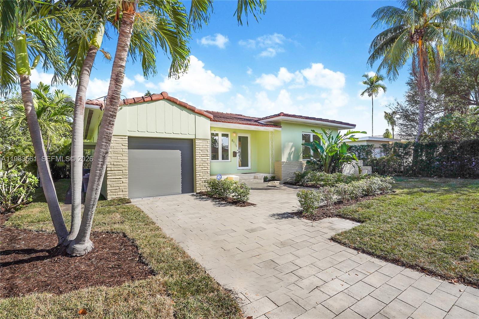 8975 Froude Avenue Surfside, FL 33154 - Photo 1 of 18 a front view of a house with garden