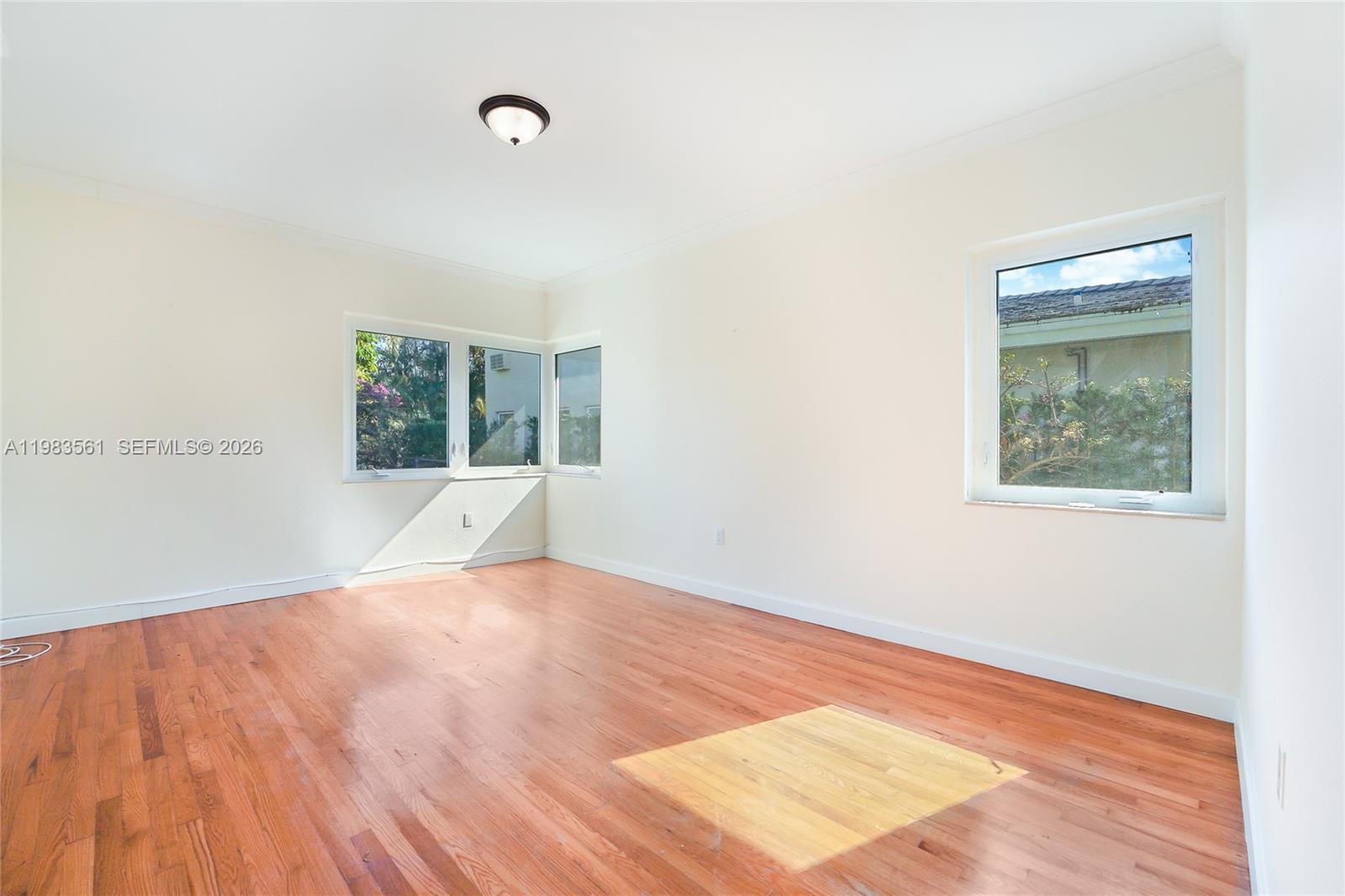 8975 Froude Avenue Surfside, FL 33154 - Photo 12 of 18 a view of an empty room with wooden floor and a window