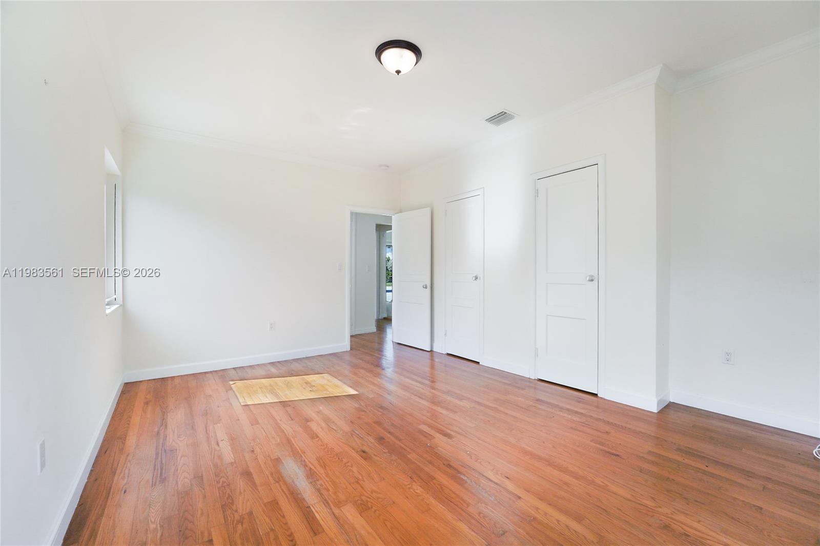 8975 Froude Avenue Surfside, FL 33154 - Photo 13 of 18 a view of an empty room with wooden floor