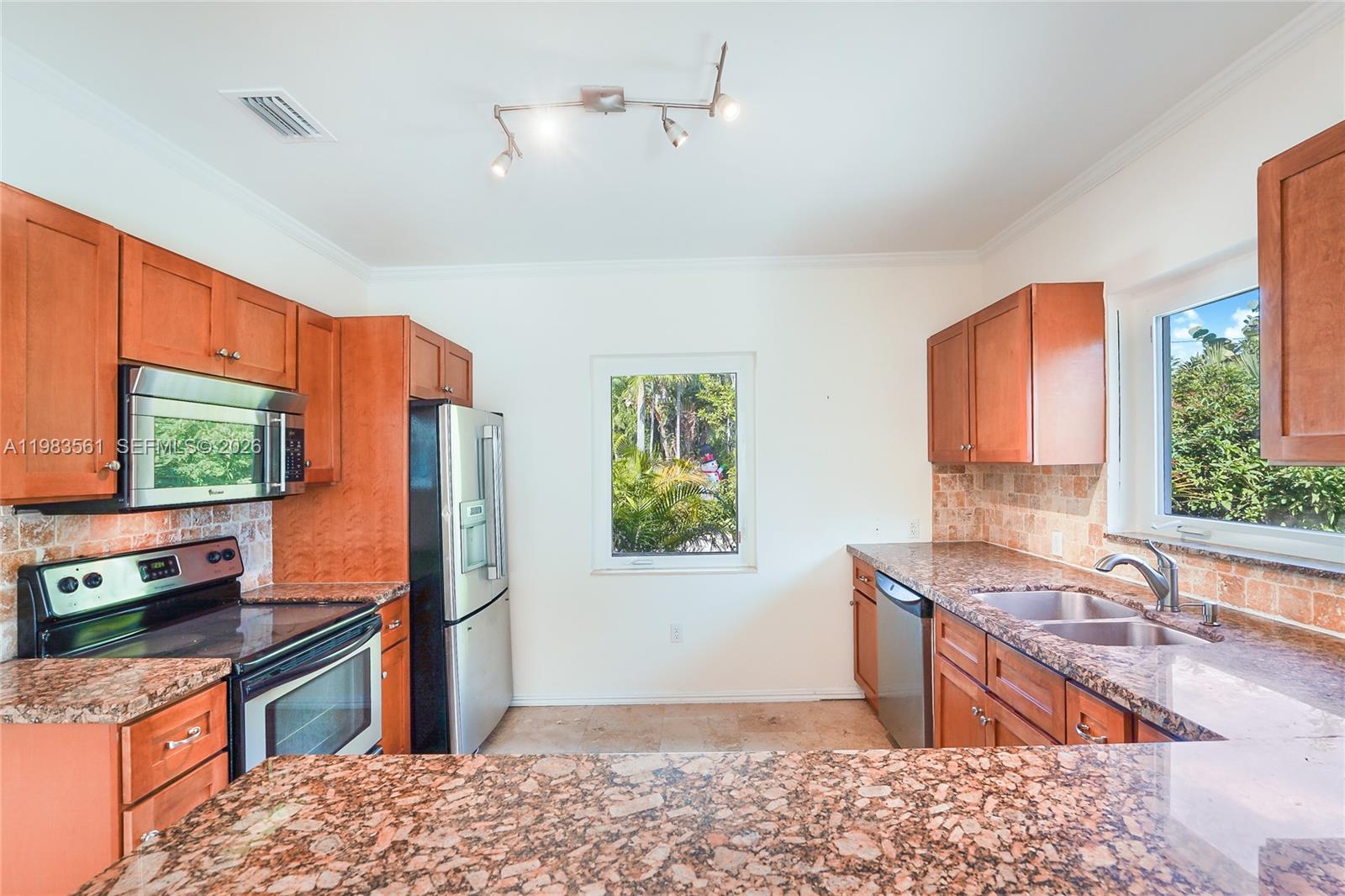 8975 Froude Avenue Surfside, FL 33154 - Photo 7 of 18 a kitchen with stainless steel appliances granite countertop a refrigerator and a sink