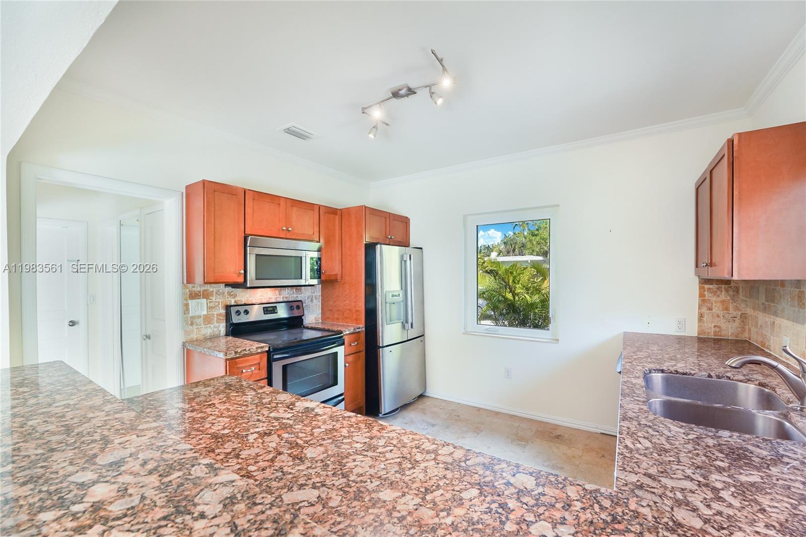 8975 Froude Avenue Surfside, FL 33154 - Photo 8 of 18 a kitchen with stainless steel appliances granite countertop a refrigerator stove and oven