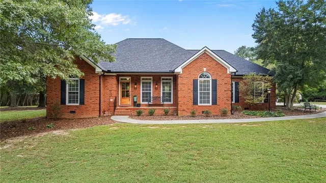 a front view of a house with a yard and trees