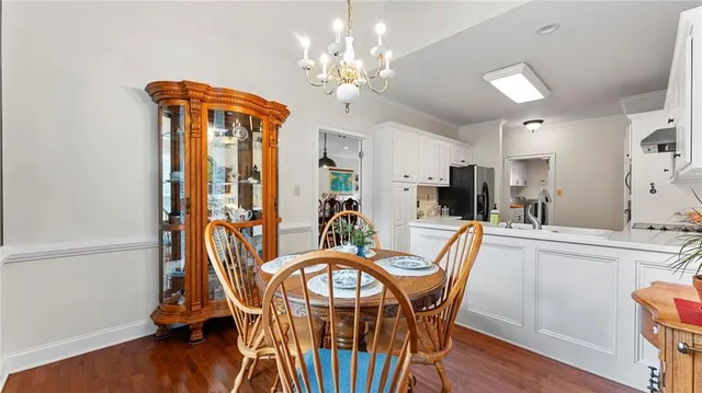 a dining room with furniture a chandelier and wooden floor