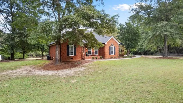a view of a house with backyard and tree