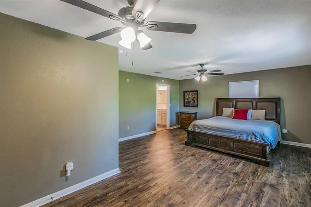 a spacious bedroom with a bed and a chandelier