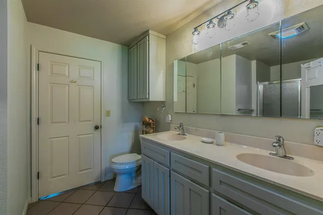 a bathroom with a sink a toilet and a mirror