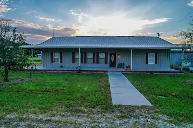 a front view of a house with a yard and outdoor seating