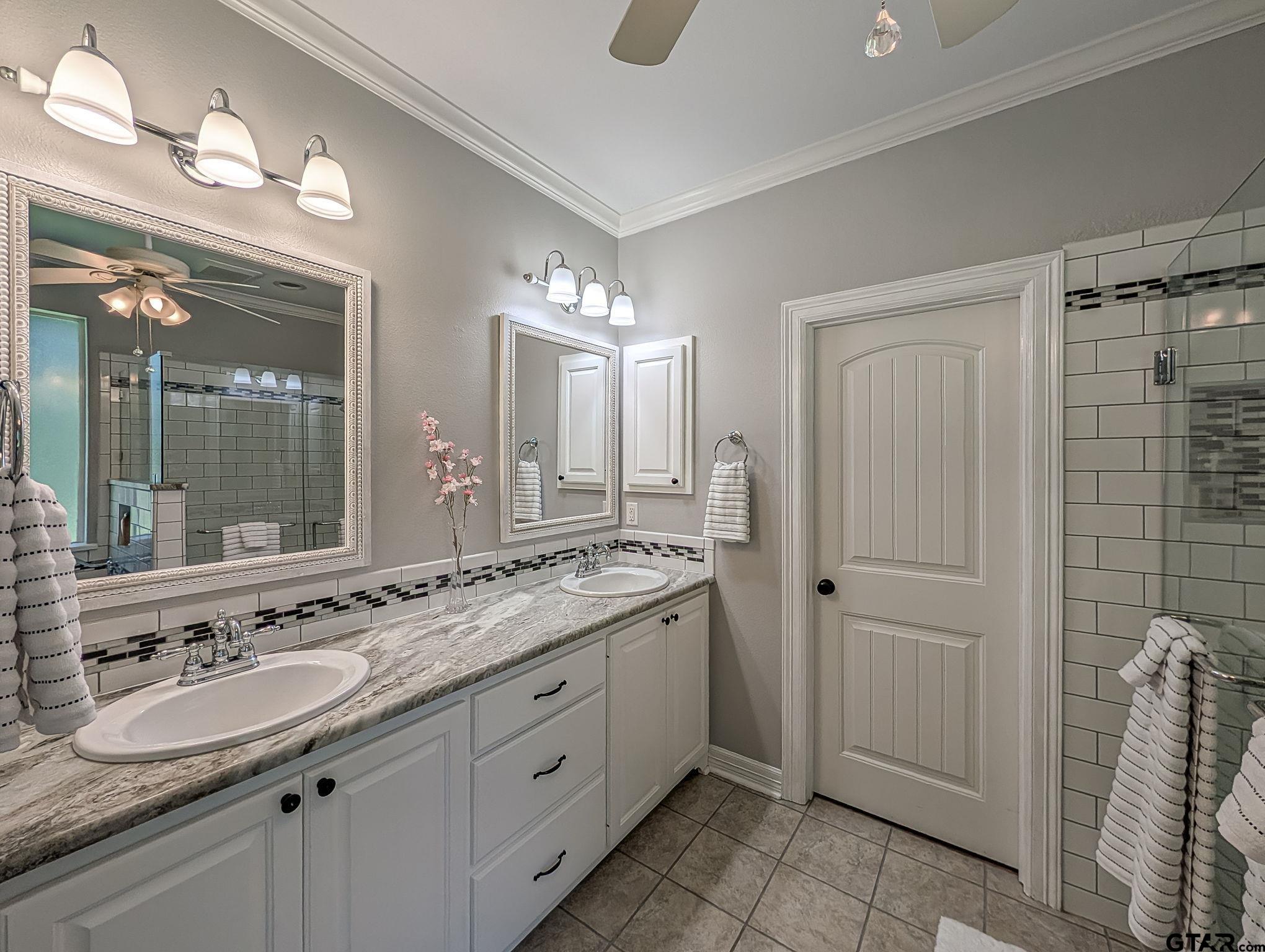 18488 Bluebird Circle Flint, TX 75762 - Photo 24 of 47 a bathroom with a granite countertop sink double vanity and a mirror