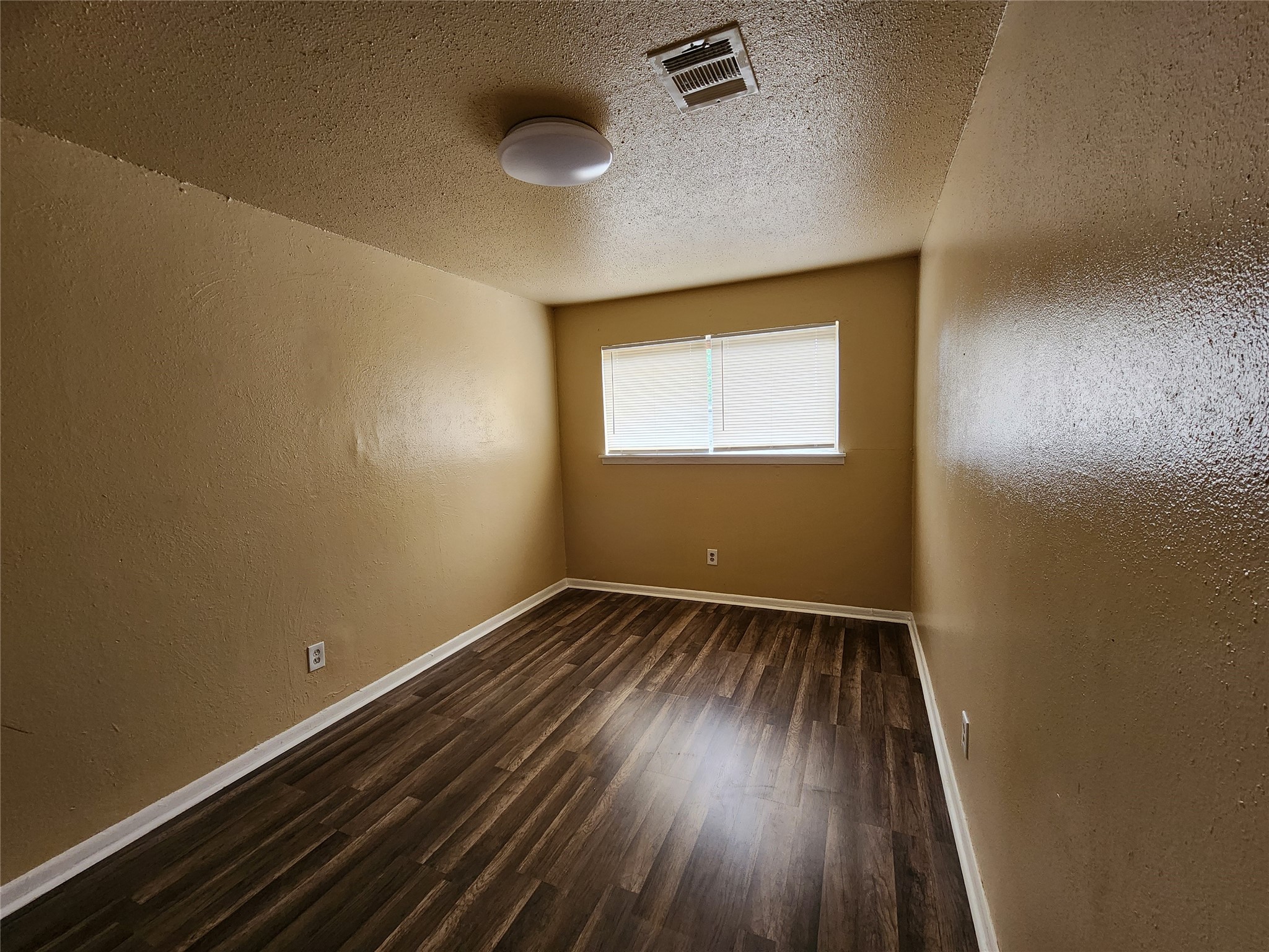 4311 Yellowstone Boulevard, Unit 6 Houston, TX 77021 - Photo 5 of 8 an empty room with wooden floor and windows