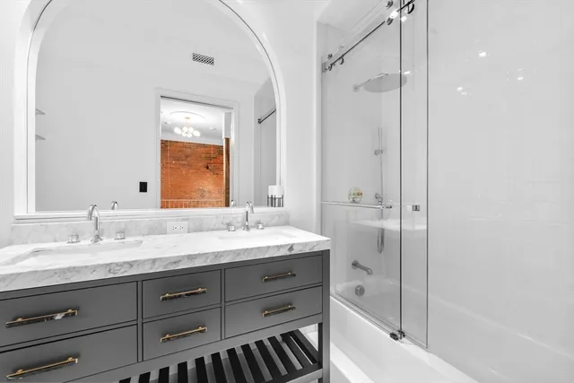 a bathroom with a granite countertop sink mirror and a bathtub