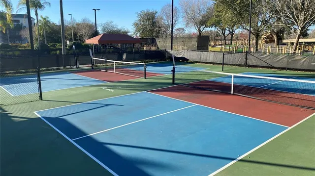 a tennis court that has the trees in the background