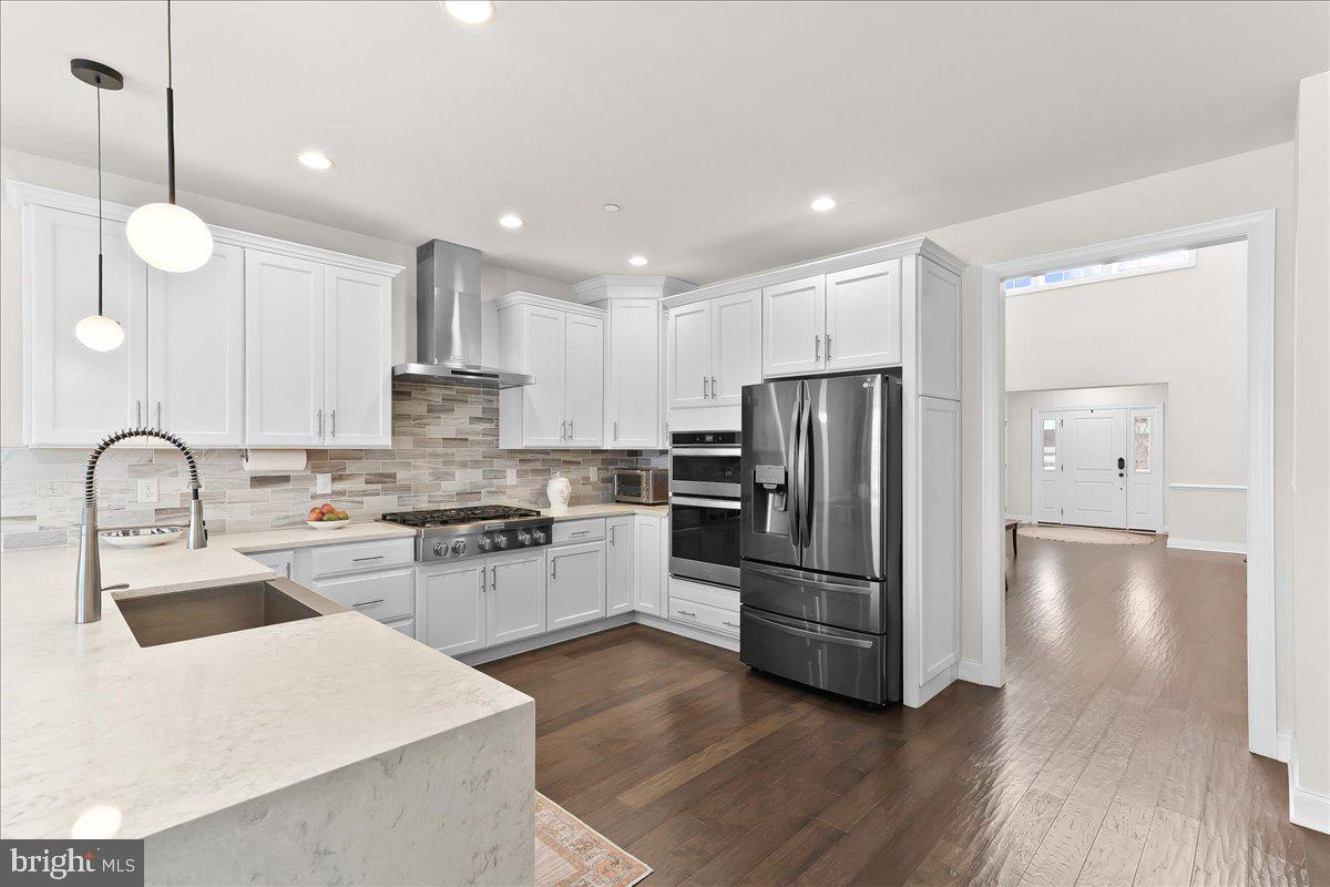 3718 Parris Boulevard Newtown Square, PA 19073 - Photo 15 of 52 a kitchen with stainless steel appliances granite countertop a refrigerator a sink a stove a microwave and wooden floor
