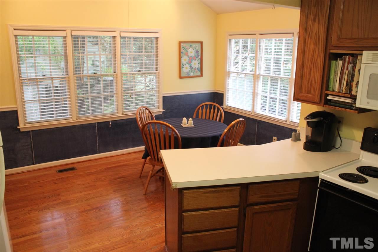 521 Mills Street Raleigh, NC 27608 - Photo 4 of 16 a kitchen with a table chairs and a window