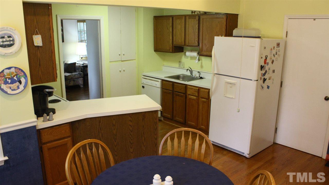 521 Mills Street Raleigh, NC 27608 - Photo 7 of 16 a kitchen with stainless steel appliances granite countertop a refrigerator a stove and a sink with wooden floor
