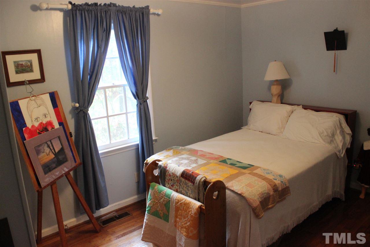 521 Mills Street Raleigh, NC 27608 - Photo 10 of 16 a bedroom with a bed and a window