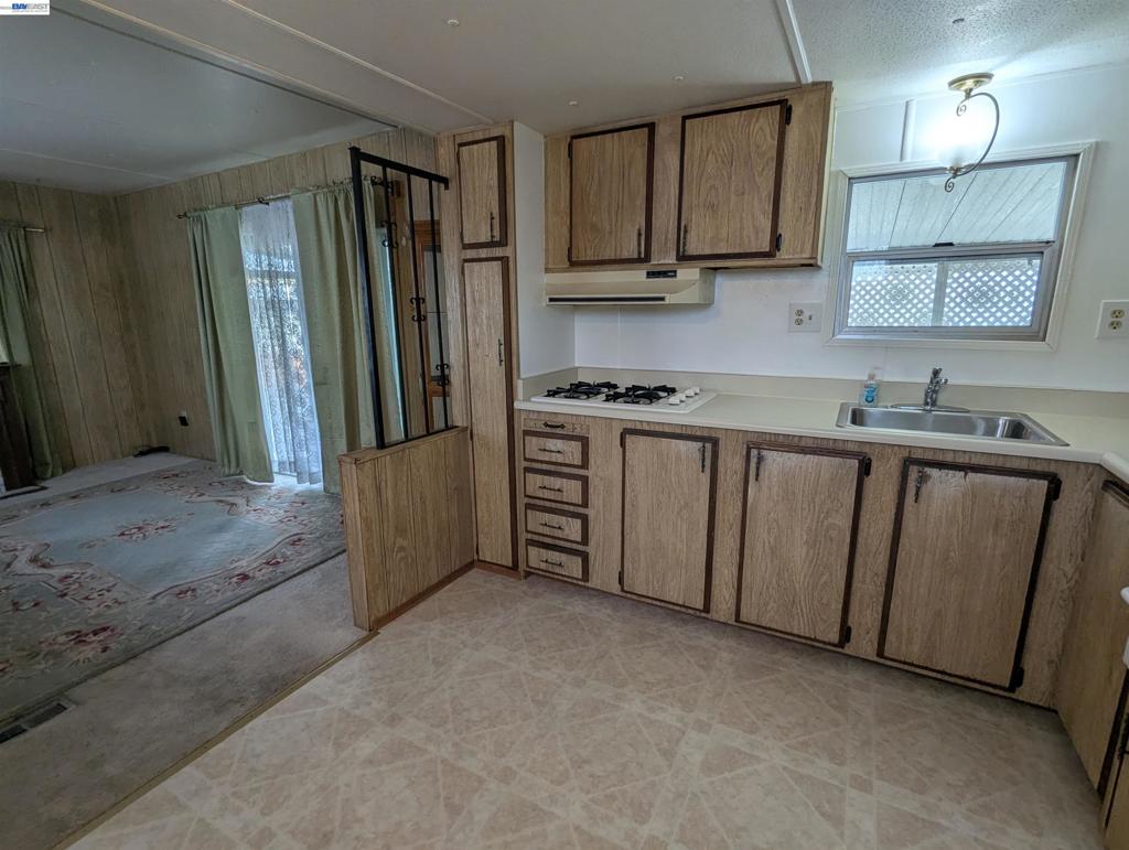 3913 Castro Valley Boulevard Castro Valley, CA 94546 - Photo 19 of 33 a kitchen with stainless steel appliances granite countertop a refrigerator a stove a sink and a granite counter tops with white cabinets