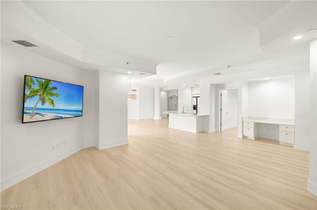 9123 Strada Place, Unit 7316 Naples, FL 34108 - Photo 11 of 47 Unfurnished living room with baseboards, ornamental molding, visible vents, and light wood finished floors