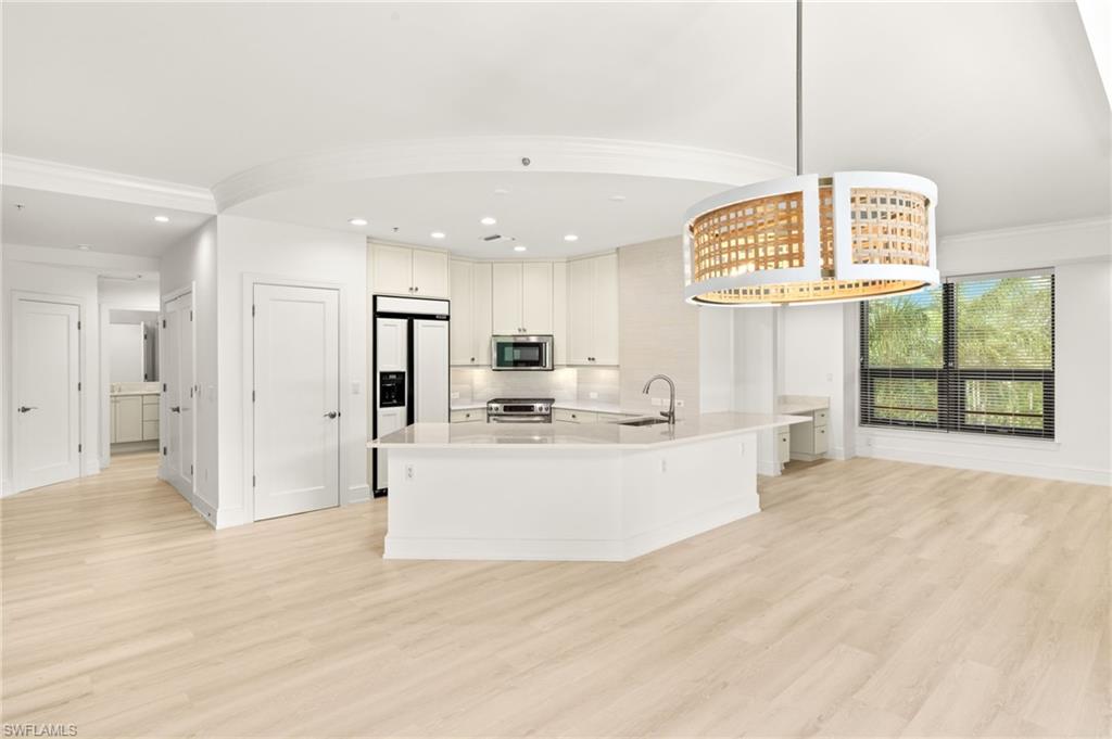 9123 Strada Place, Unit 7316 Naples, FL 34108 - Photo 14 of 47 Kitchen featuring light countertops, a sink, stainless steel appliances, and light wood finished floors