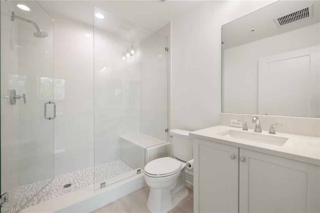 9123 Strada Place, Unit 7316 Naples, FL 34108 - Photo 26 of 47 Full bath with visible vents, toilet, vanity, and a stall shower