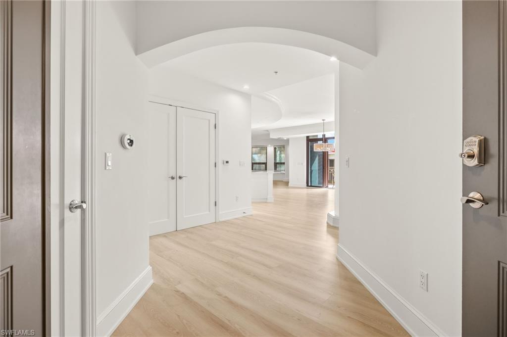 9123 Strada Place, Unit 7316 Naples, FL 34108 - Photo 6 of 47 Corridor featuring baseboards and light wood-style flooring