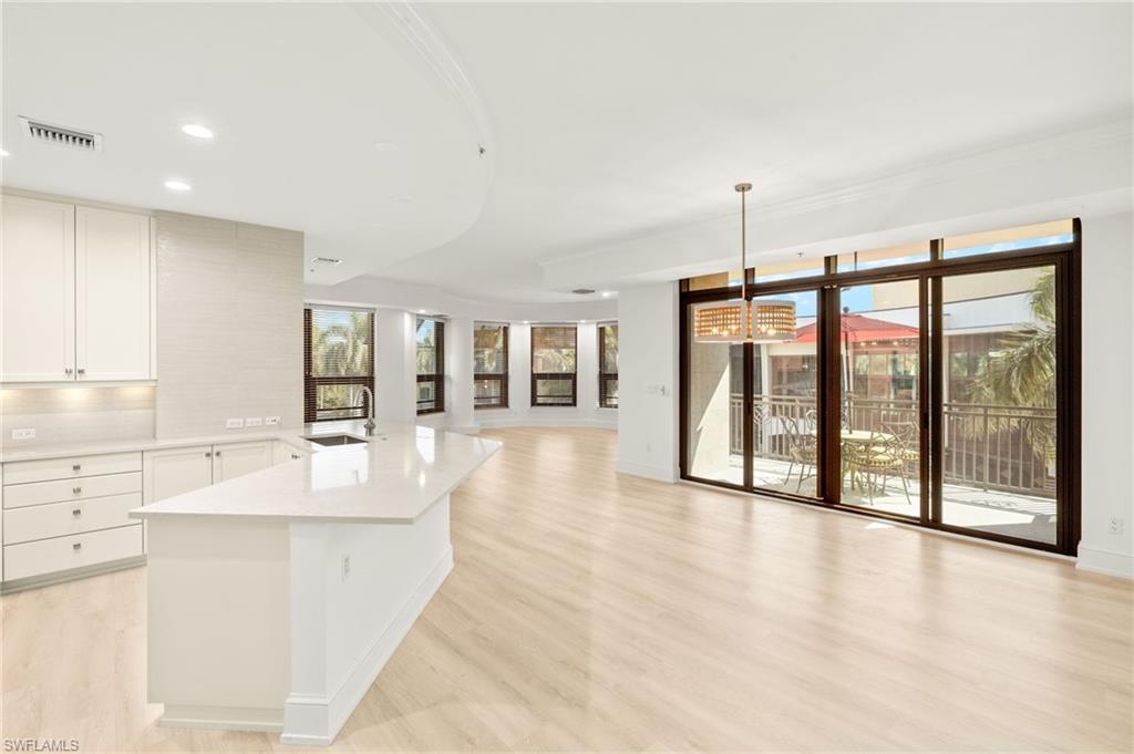 9123 Strada Place, Unit 7316 Naples, FL 34108 - Photo 10 of 47 Kitchen with an inviting chandelier, light countertops, a healthy amount of sunlight, and light wood-style flooring