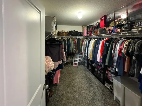 a view of walk in closet with clothes