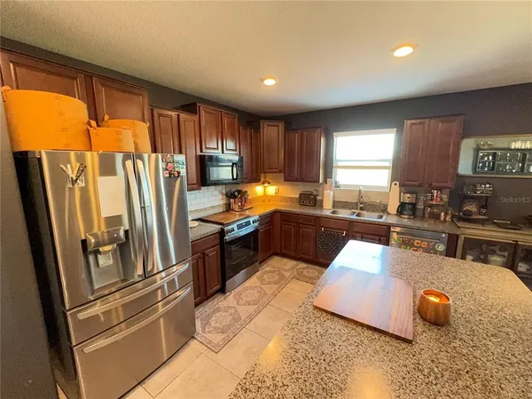 a kitchen with stainless steel appliances a refrigerator sink and cabinets
