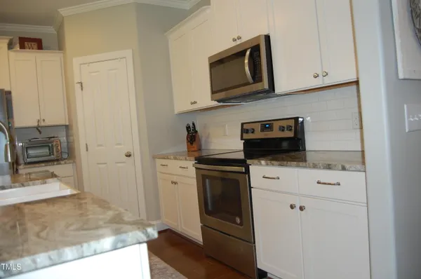 a kitchen with stainless steel appliances white cabinets and a sink