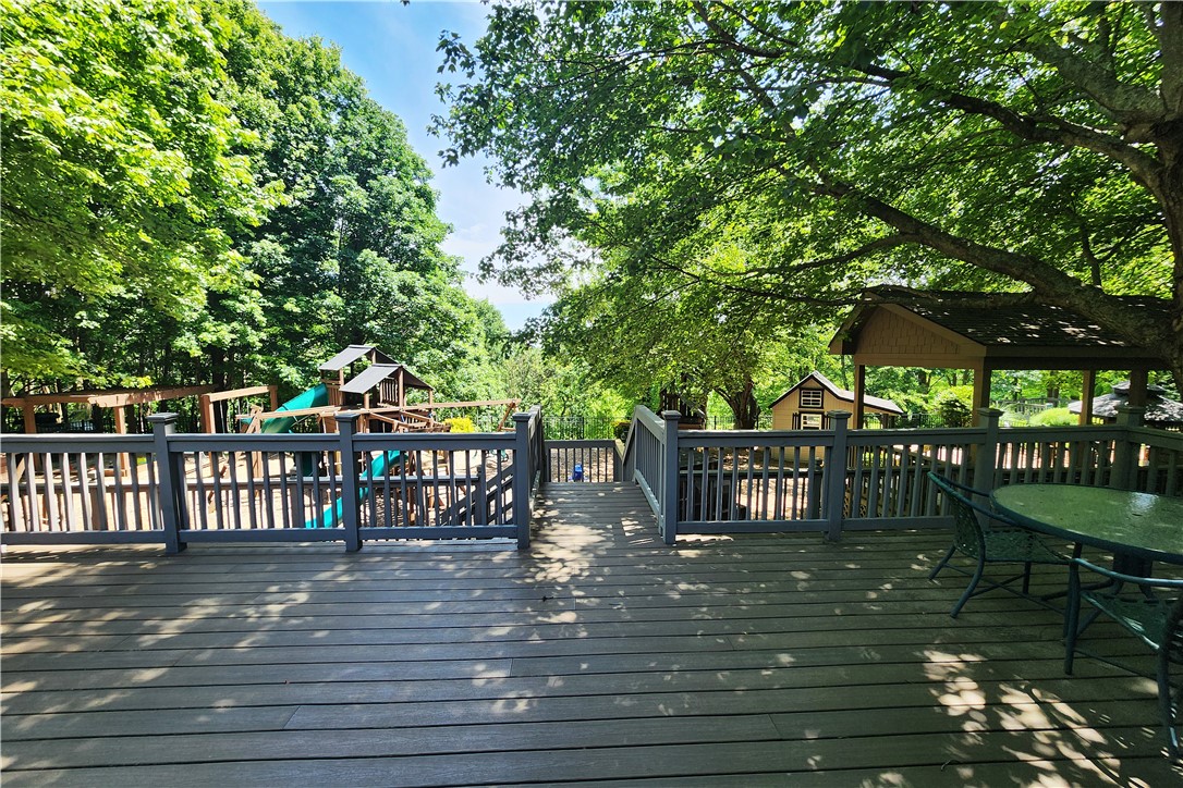 39 Raptor Way Landrum, SC 29356 - Photo 15 of 50 Enjoy outdoor living with a spacious deck overlooking a vibrant playground and lush greenery.