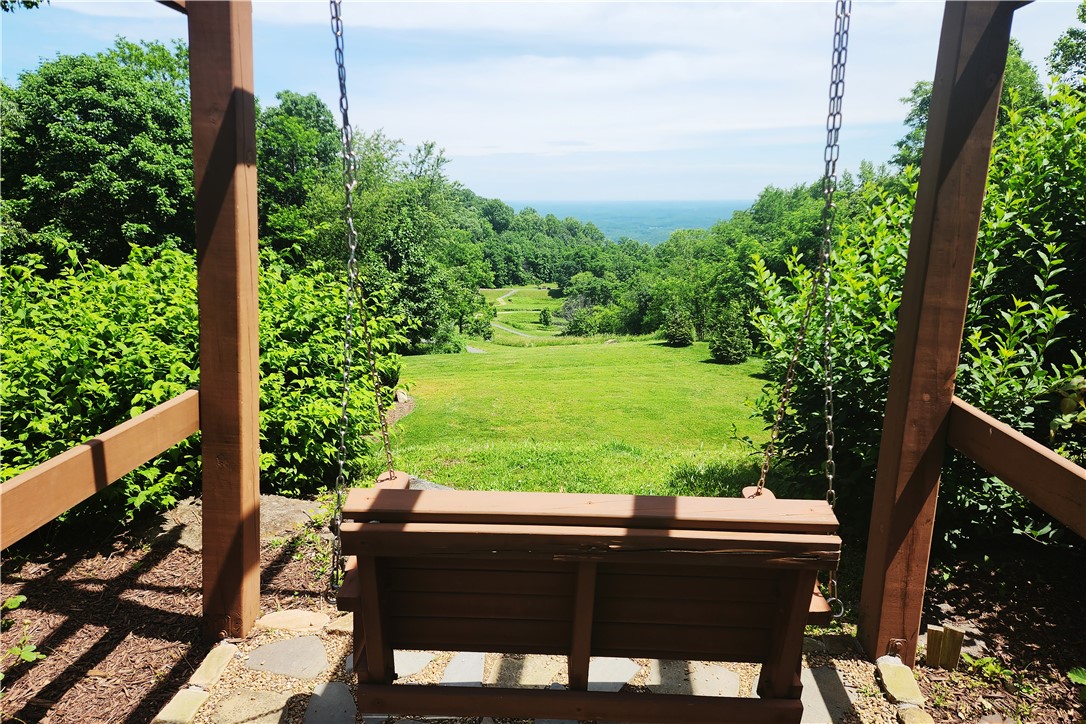 39 Raptor Way Landrum, SC 29356 - Photo 23 of 50 Enjoy the expansive mountain landscape from this inviting outdoor swing area, perfect for relaxation.