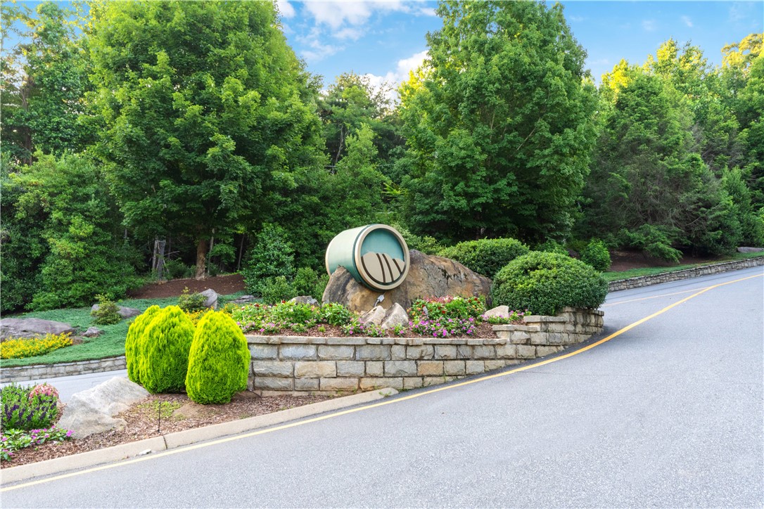 39 Raptor Way Landrum, SC 29356 - Photo 50 of 50 This scenic entrance, bordered by vibrant trees and stone landscaping, welcomes you home.