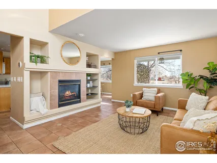 a living room with furniture a fireplace and a large window
