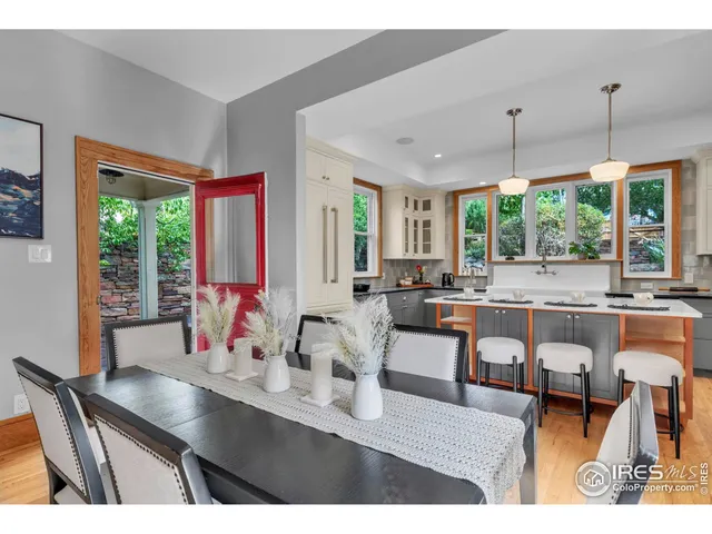 a dining room with furniture a chandelier and large windows