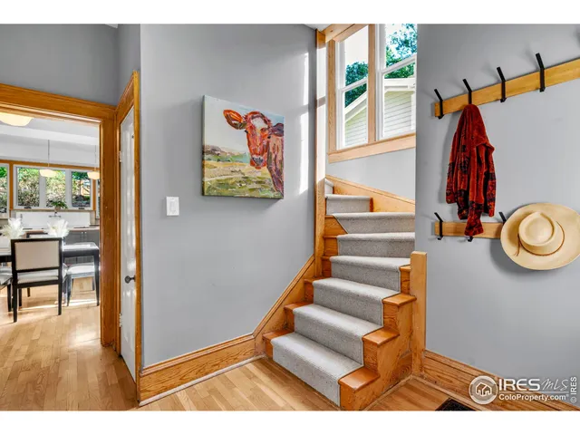 a living room with furniture and a dining table with chandelier