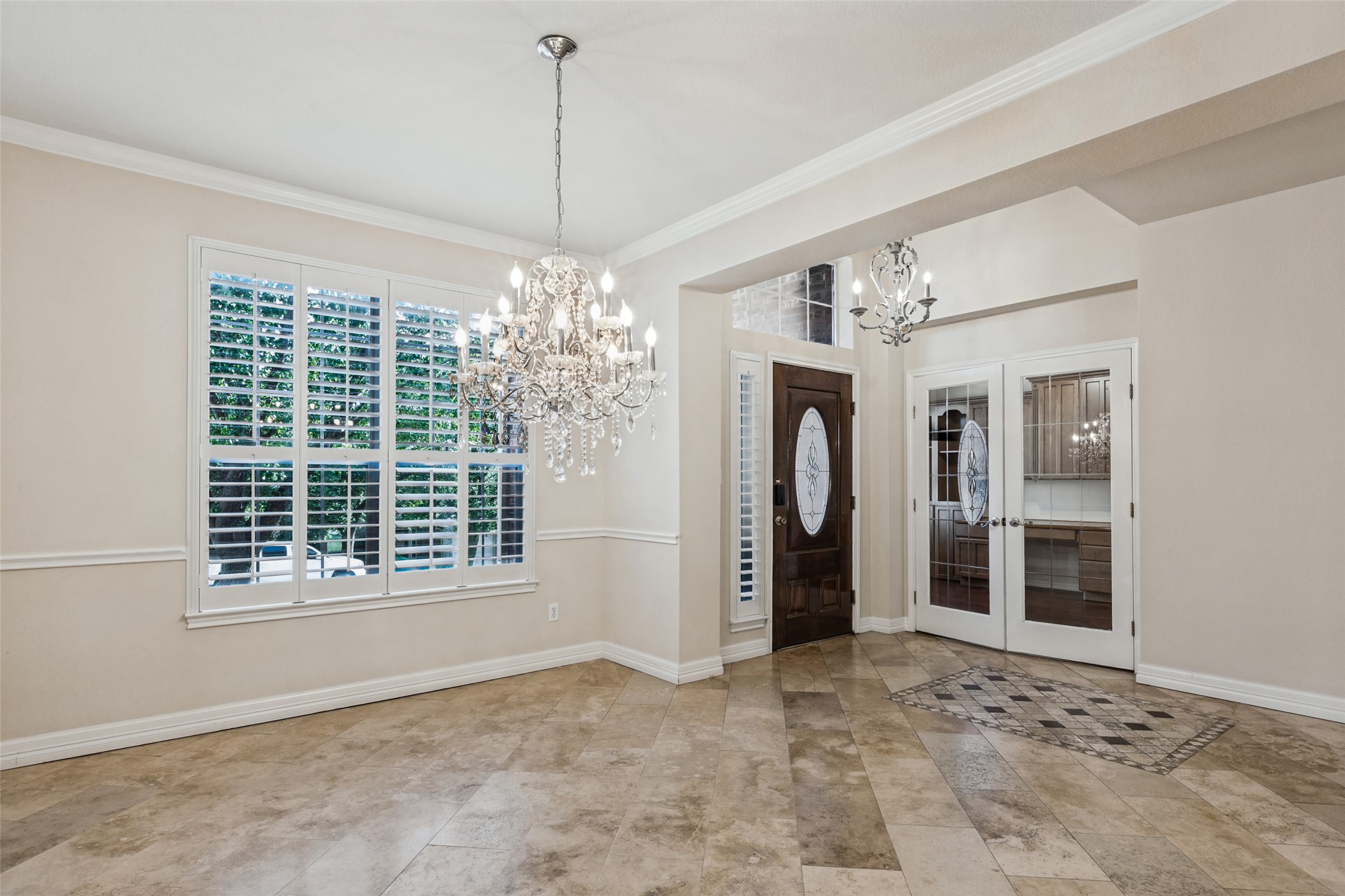 2832 Grimes Ranch Road Austin, TX 78732 - Photo 3 of 23 Gleaming tile floors and detailed crown molding elevate this open entry hall and dining space.