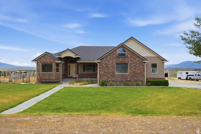 2567 West Rim Rock Drive Stockton, UT 84071 - Photo 2 of 64 Brick and siding exterior featuring a covered entry and arched transom window