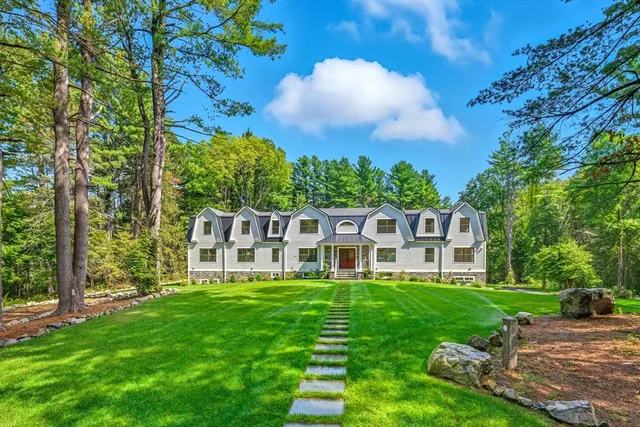 a view of a house with a big yard and large trees