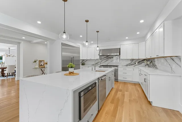 a kitchen with stainless steel appliances granite countertop a sink a stove and a refrigerator