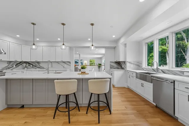 a kitchen with kitchen island granite countertop a sink and white cabinets